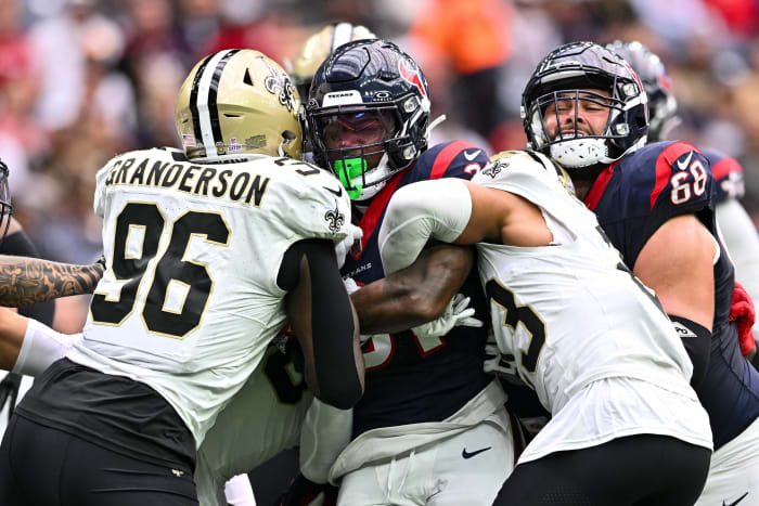 Saints defensive tackles and cornerback wrap up Houston Texans running back Dameon Pierce during the first quarter at NRG Stadium.